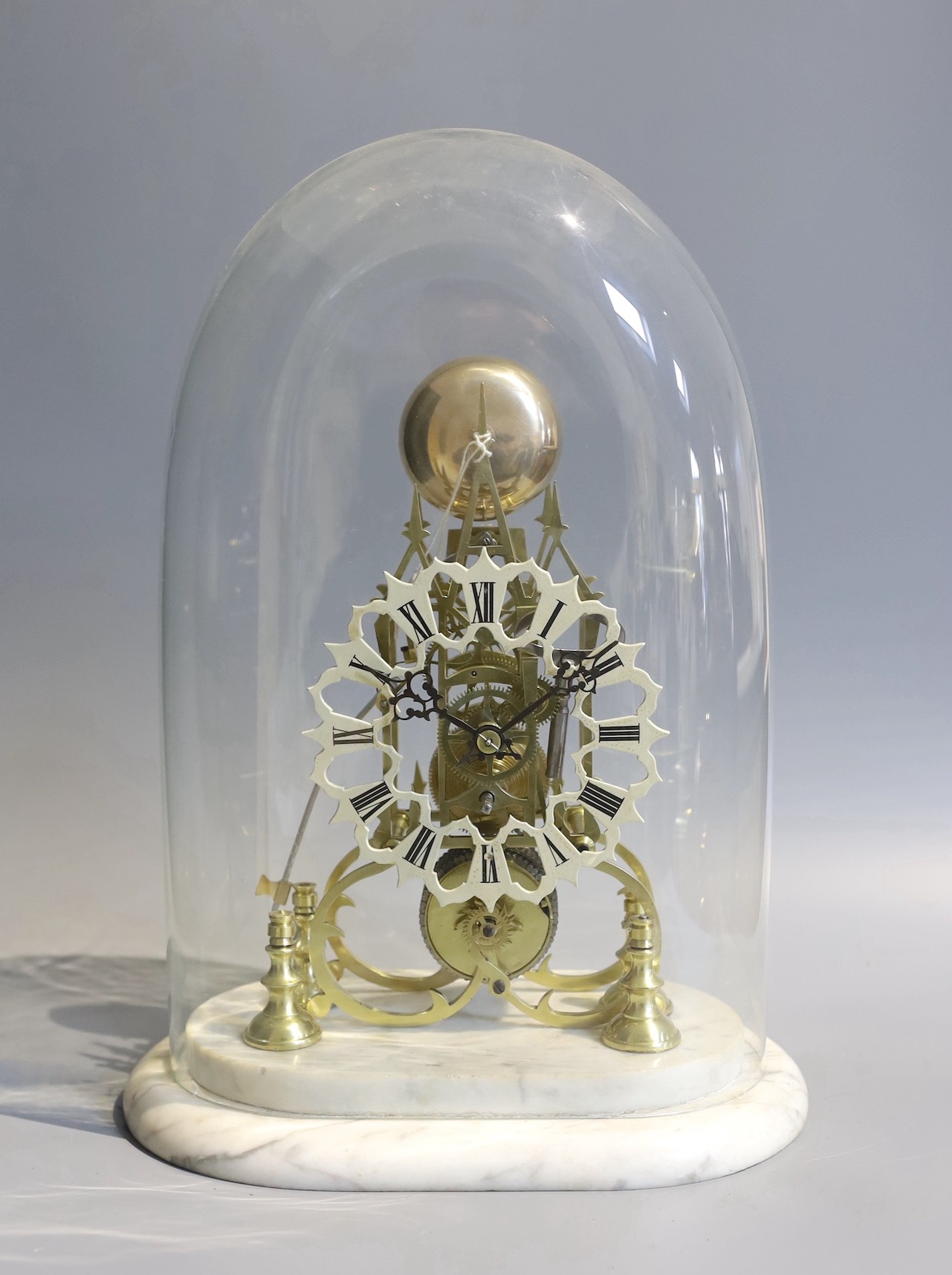 A 19th century brass skeleton mantel clock, under glass dome, with marble plinth, passing strike, the single fusee movement, with passing strike and a pierced enamelled chapter ring, height 36cm